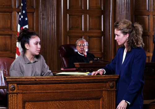 Where does the defense attorney sit in the courtroom?